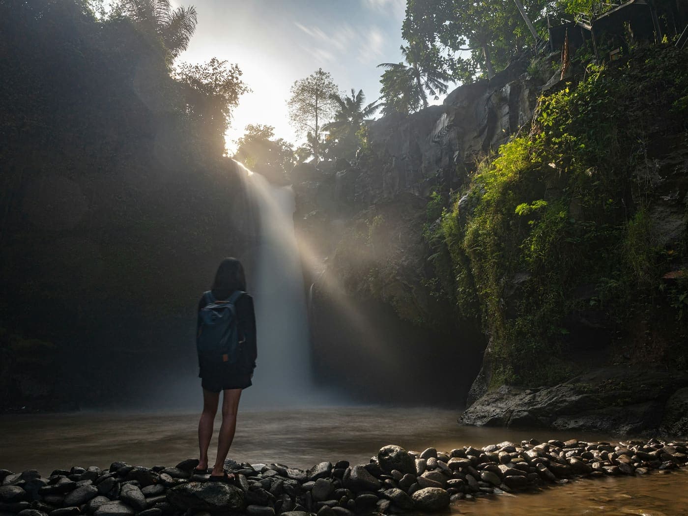 Excursionista mirando una cascada en el bosque